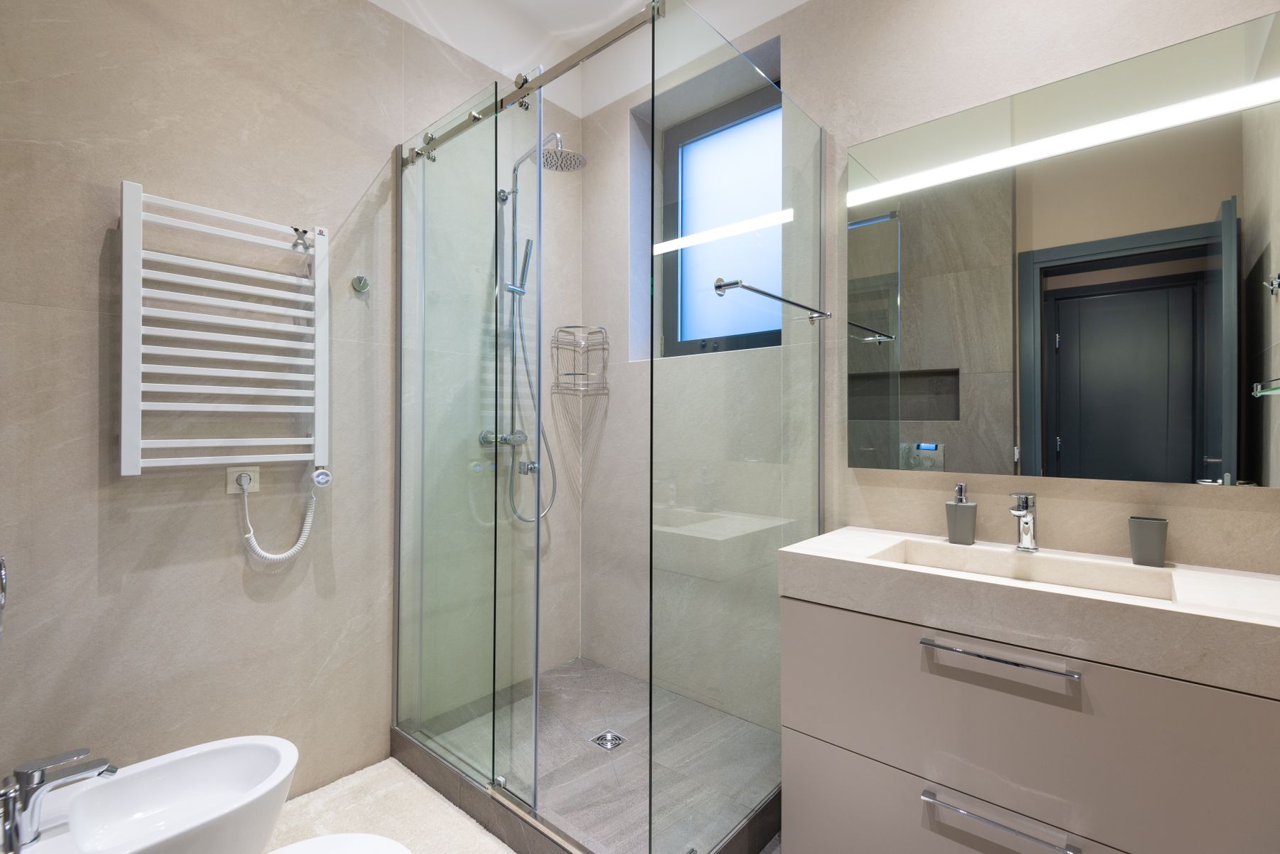 A renovated bathroom with a tiled walk-in shower and modern vanity